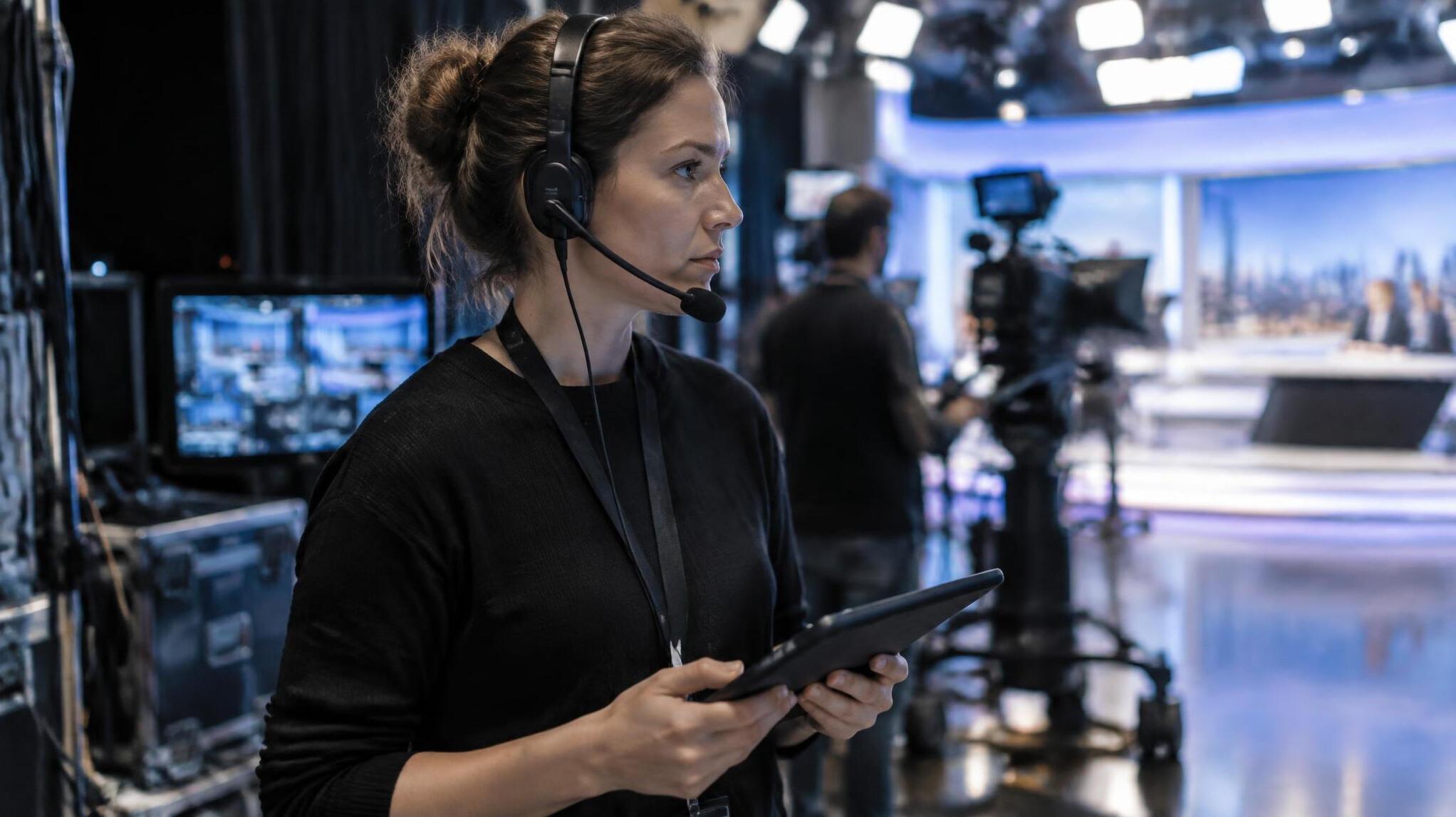 Producer speaking into a headset backstage during a live broadcast